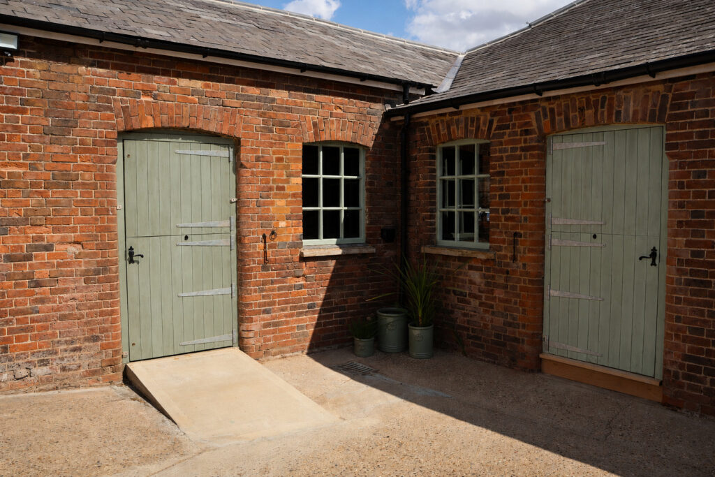 Sage-green entrance doors at The Stable Studio