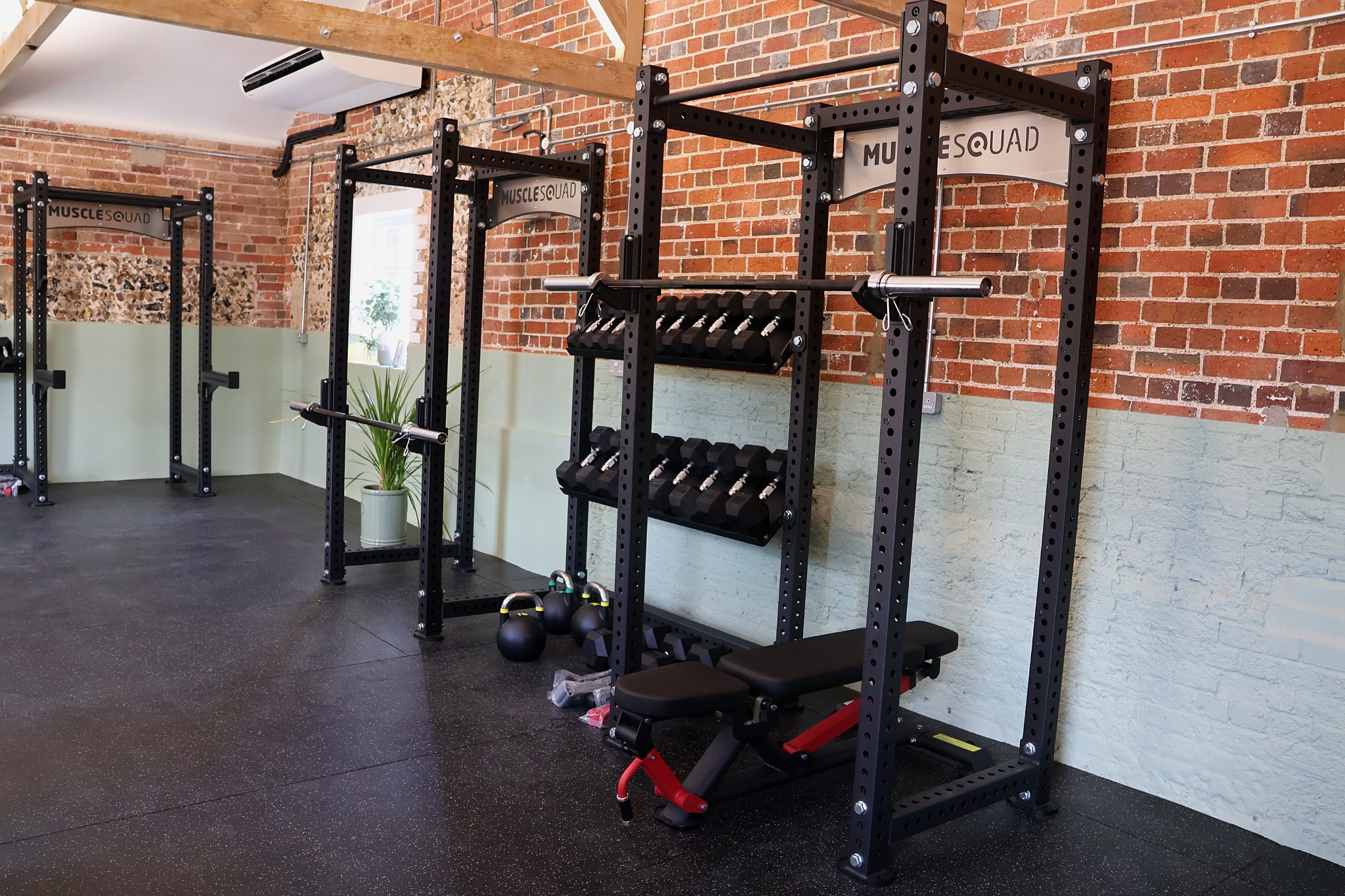 Strength racks, free weights and benches inside The Stable Studio